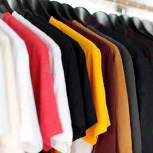 Verschillend gekleurde T-shirts aan een rek
