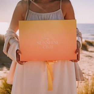 Vrouw die doos vasthoudt met 'sunshine club' op